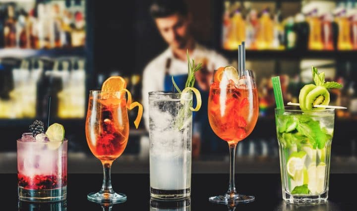 5 drinks enfileirados em um balcão de bar